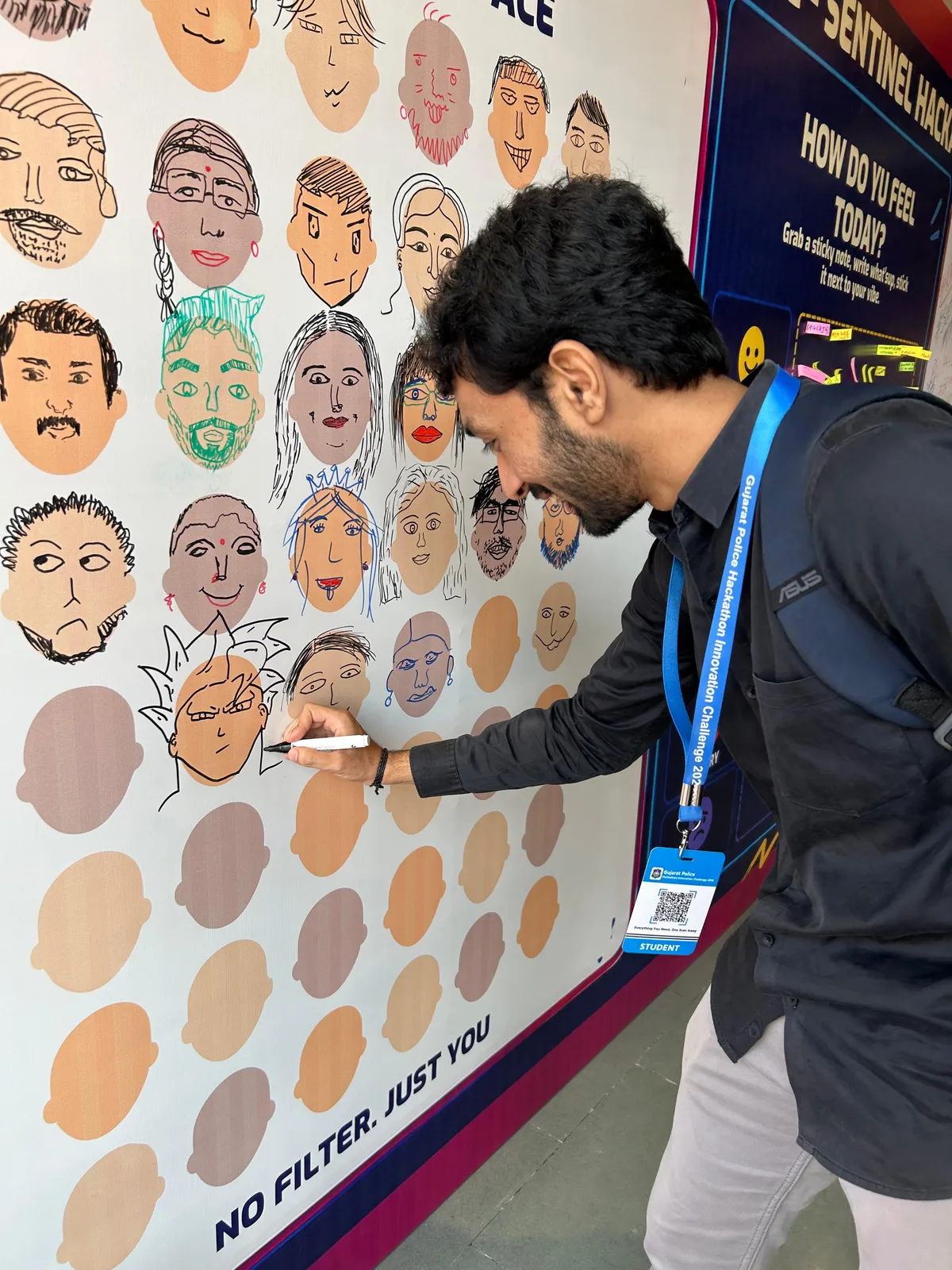 Vatsal Mehta drawing on the faces wall at Sentinel Hackathon 2026